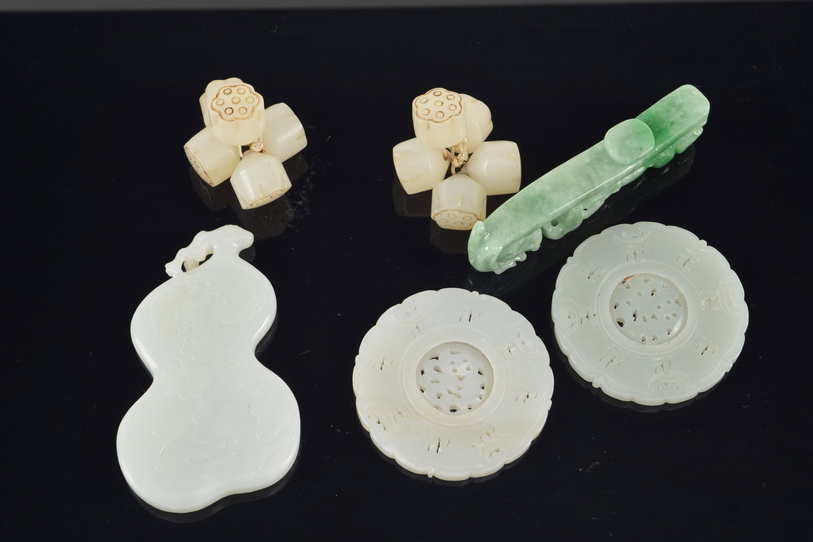 4 jade pendants. China. 19th century. Together with a group of jade lotus beads. Largest 3in. - 6