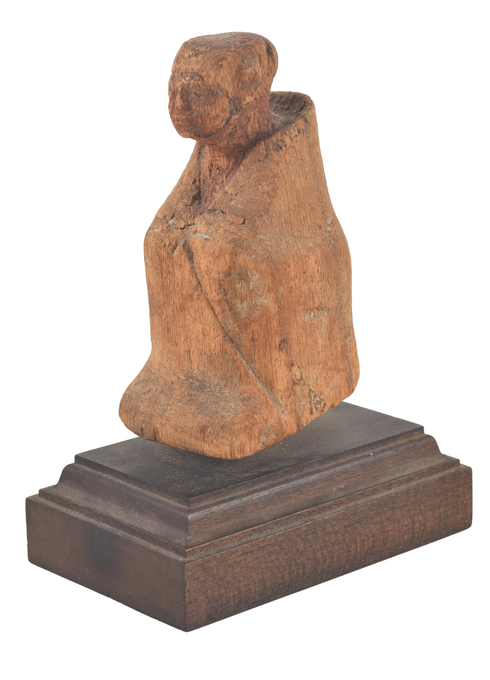 Egyptian, 12th Dynasty, wood figure of an official. Crouching and wrapped in a cloak, traces of: Egyptian, 12th Dynasty, wood figure of an official. Crouching and wrapped in a cloak, traces of paint. On a wood base. Height. 3.75 in. From the collection of Dr. Bruce L. Ralston, Tuxedo Park NY. Dr.