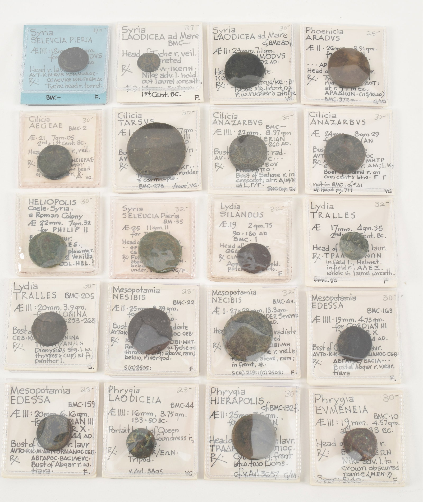 20 ancient bronze coins, each cased and identified. Including coins from Syria, Lydia, Cilicia, (1 of 11)