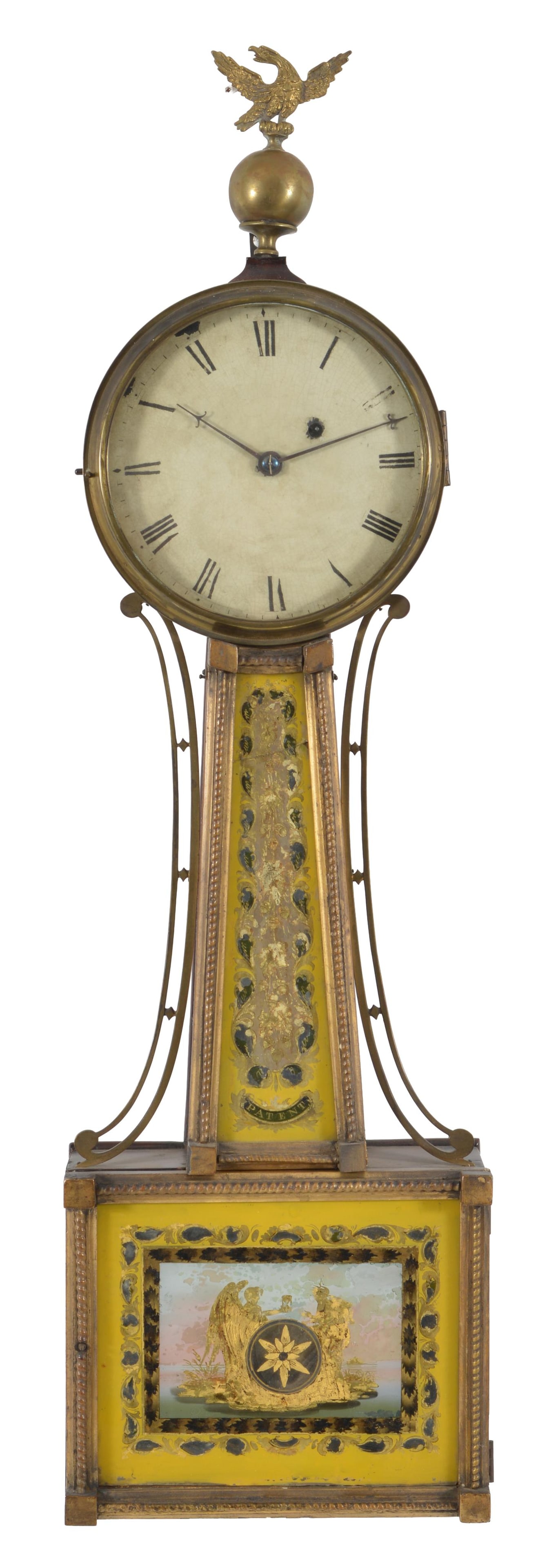 Boston banjo clock with gilt rope frames and rare yellow glasses, circa 1820. A spread wing and ball: Boston banjo clock with gilt rope frames and rare yellow glasses, circa 1820. A spread wing and ball finial above a dial with Roman numerals and yellow and gilt reverse painted glasses. The lower glas