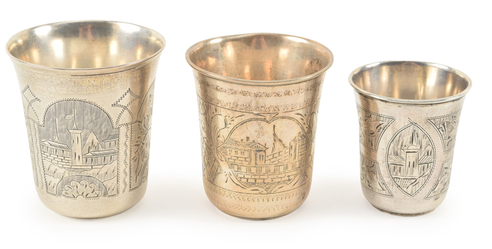 3 Russian silver beaker cups. Each beaker finely engraved: fortress walls with towers under a flag,: 3 Russian silver beaker cups. Each beaker finely engraved: fortress walls with towers under a flag, an architectural scene with bridge and tower, and a medallion with tower and floral rosettes. 84 zol