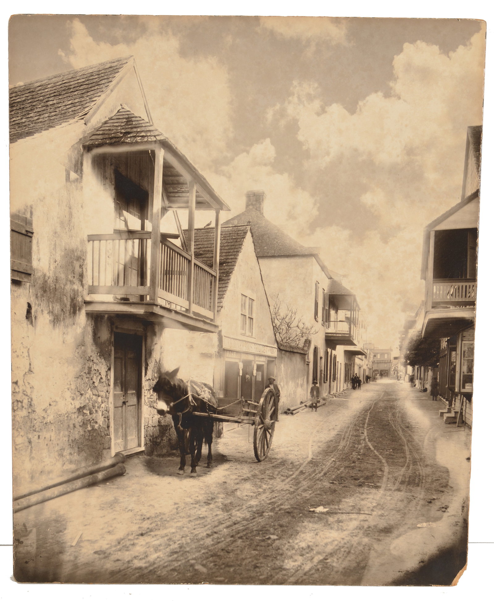 George Barker. Canada. Large format 19th century photograph depicting a street scene in St.: George Barker. Canada. Large format 19th century photograph depicting a street scene in St. Augustine, Florida. A horse-drawn wagon waits outside of "Gardiner Bros. Produce" store with several African