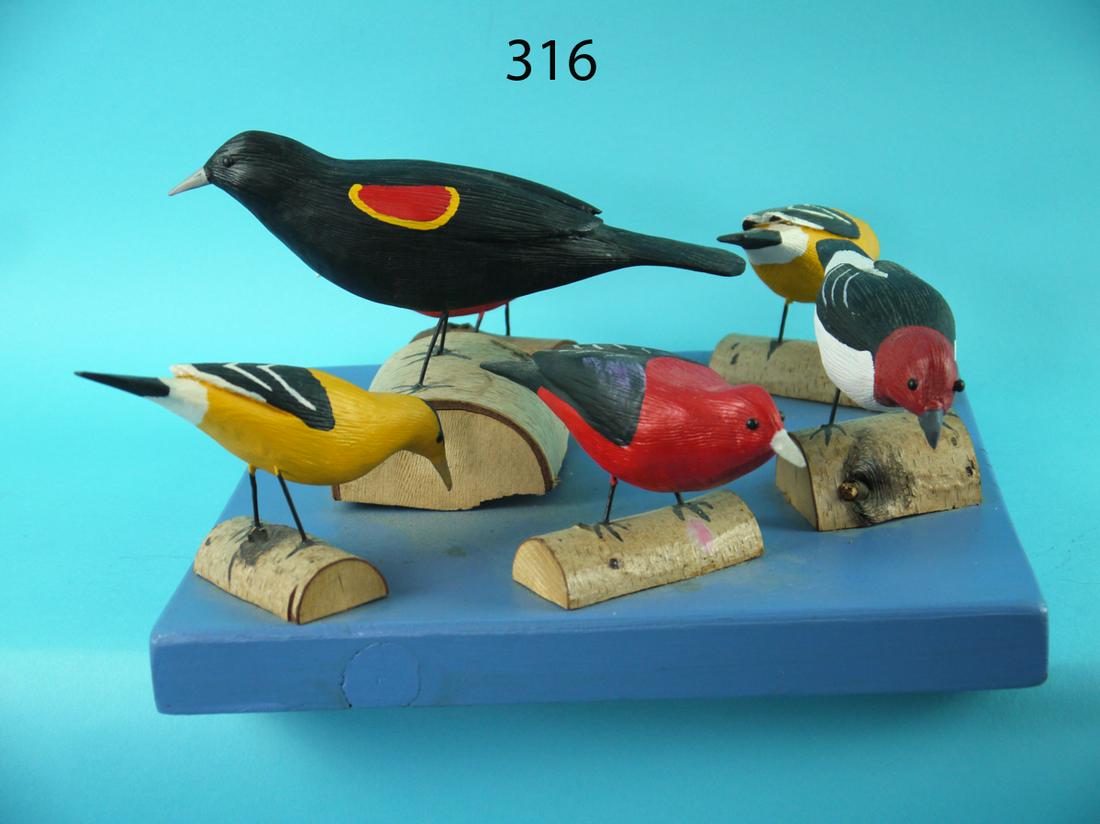 SIX SONG BIRDS ON PANEL, C. FOREMAN: SIX SONG BIRDS ON PANEL by Charles Foreman, Manahawkin, NJ. Group consists of two goldfinch, two scarlet tanagers, one red-headed woodpecker and one red-wing blackbird. Five carved in feeding position