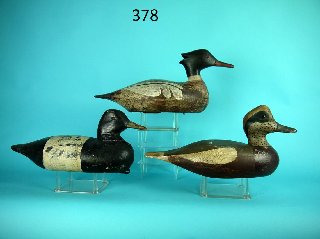 THREE WORKING DECOYS: THREE WORKING DECOYS. The first is a BLUEBILL DRAKE. The second is a WIDGEON DRAKE. The third is a MERGANSER DRAKE. All repainted and in fair structural condition. Two with replaced heads. 75-125