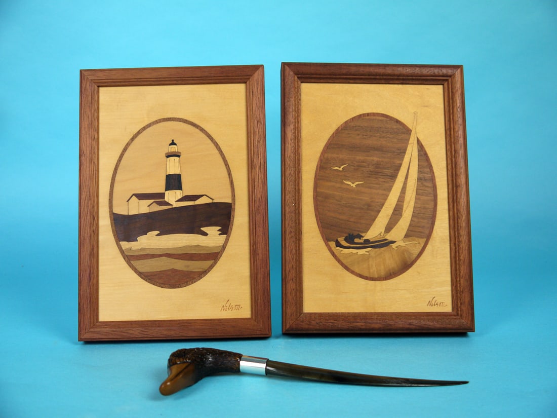 TWO NAUTICAL SCENES, LETTER OPENER: TWO NAUTICAL SCENES depicting the Montauk Lighthouse and sailboat. Each area of the design is inlaid with global wood. Country of original of each section of inlay is outlined on the verso. "Nelson"