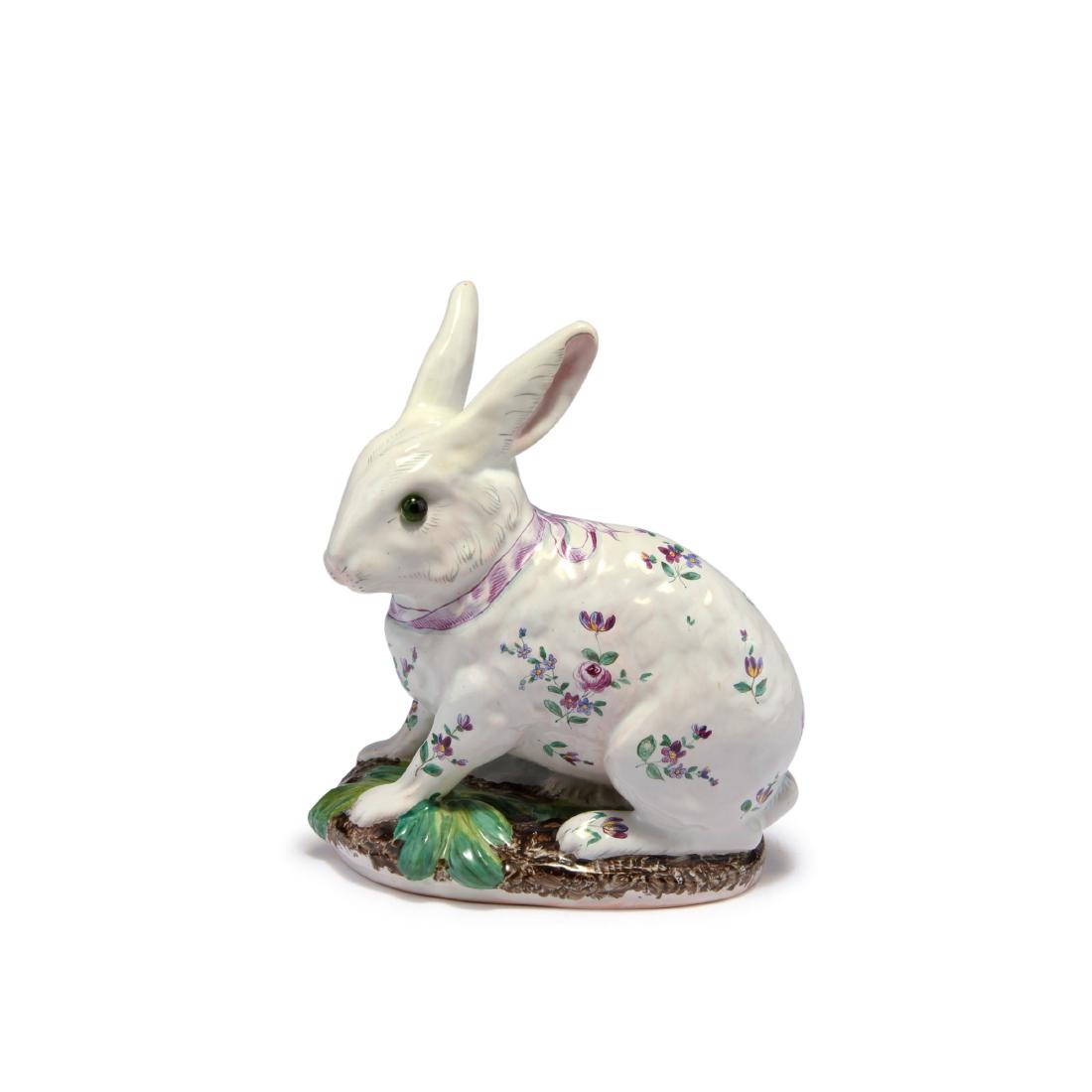 Bunny, prior to 1878: H. 20 cm. Made in St. Clement. Faience (Terre de Lorraine), glazed white, green and dark brown. Polychromatic flower paint. Green glass beads as eyes. Signed: Galle Nancy.