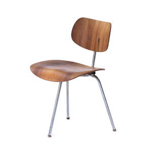 'SE 69' three-legged chair, 1952: Egon Eiermann , H. 74 x 46.5 x 48 cm. Made by Wilde & Spieth, Esslingen, c. 1952. Chrome-plated tubular steel, ply, nut veneer, black rubber feet. Marked: Remains of a paper label.