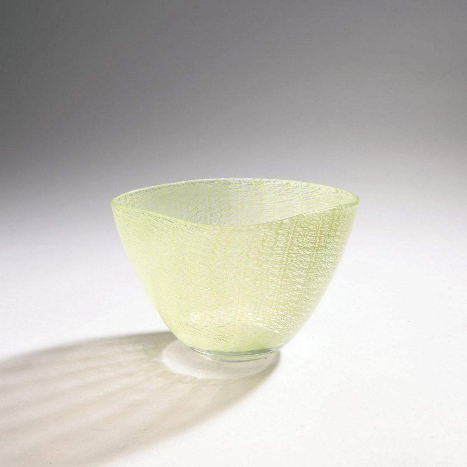 Archimede Seguso, 'Merletto' vase, c. 1952: Archimede Seguso, 'Merletto' vase, c. 1952, On a round base extending to the four-sided mouth. H. 12.5 cm. Execution: Vetreria Archimede Seguso. Cased glass, colorless, melted bands with green 'merlet
