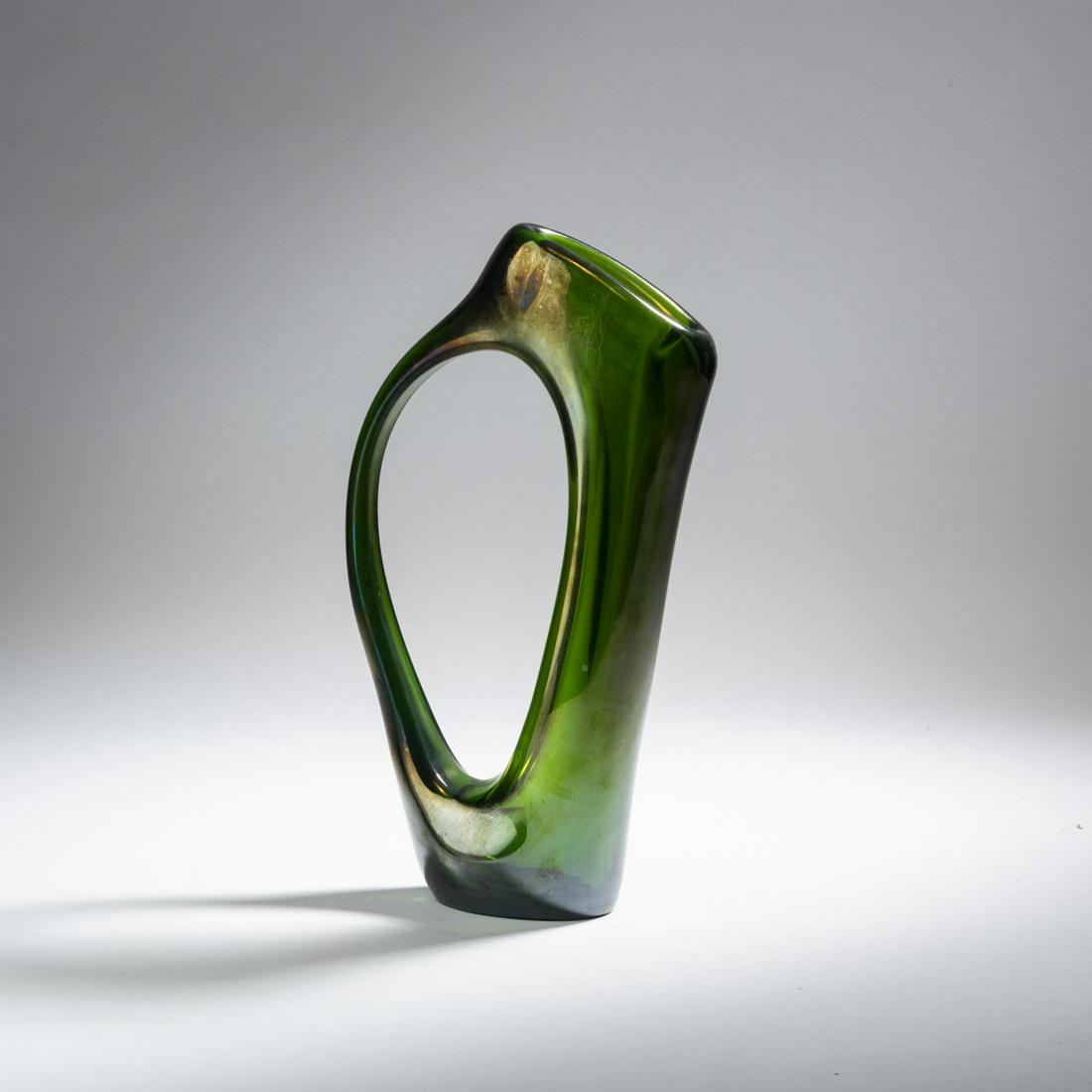 Giorgio Ferro, 'Anse volante' vase, c. 1952: Giorgio Ferro, 'Anse volante' vase, c. 1952, Ring-like body on both sides, strongly flattened, on an oval stand. H. 31 cm. Execution: A.Ve.M. Thick glass, green, iridescent.,