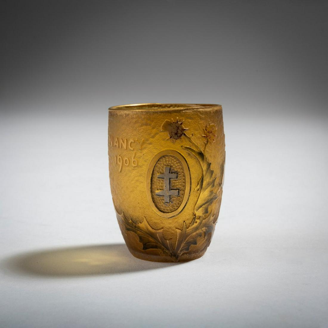 Daum Frères, Nancy, Miniature vase 'Nancy 1906': Daum Frères, Nancy, Miniature vase 'Nancy 1906', H. 4.8 cm. Overlaid glass, amber and clear, etched and polychrome enamelled as well as gold-plated and silver-plated. Motif with the Lorraine cr