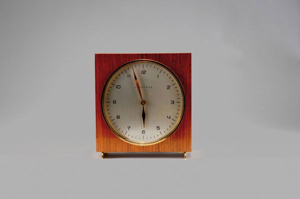 Max Bill: Max Bill. Table clock, designed in 1959. H. 17.5 x 16.2 x 7.5 cm. Made by Junghans, Schramberg. Plywood with nutwood veneer, brass. Marked: JUNGHANS MADE IN GERMANY.