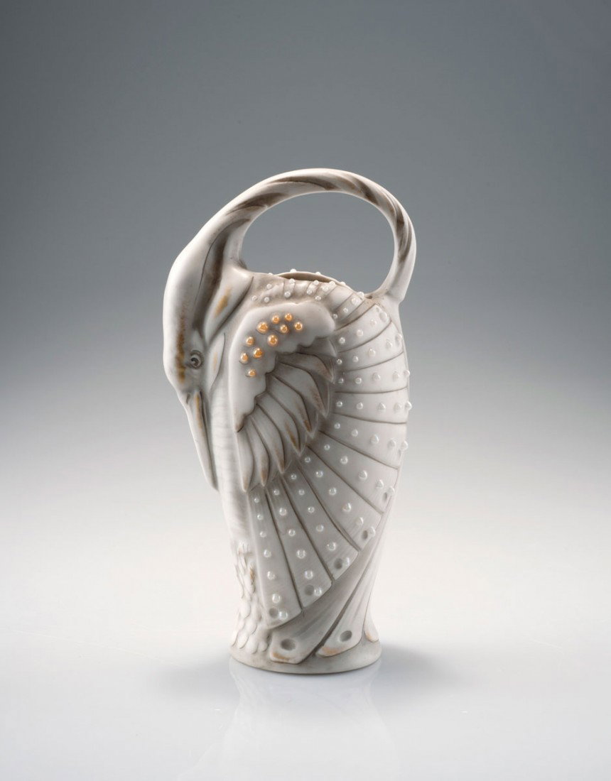 Kanne in Form eines Vogels, um 1899: Amphora-Werke Riessner, Stellmacher & Kessel, Turn-Teplitz (attributed). Jug in the shape of a bird, circa 1899. H. 23 cm. Porcelain faience, white, glazed grey, gold, white and orange enamel. Marked: