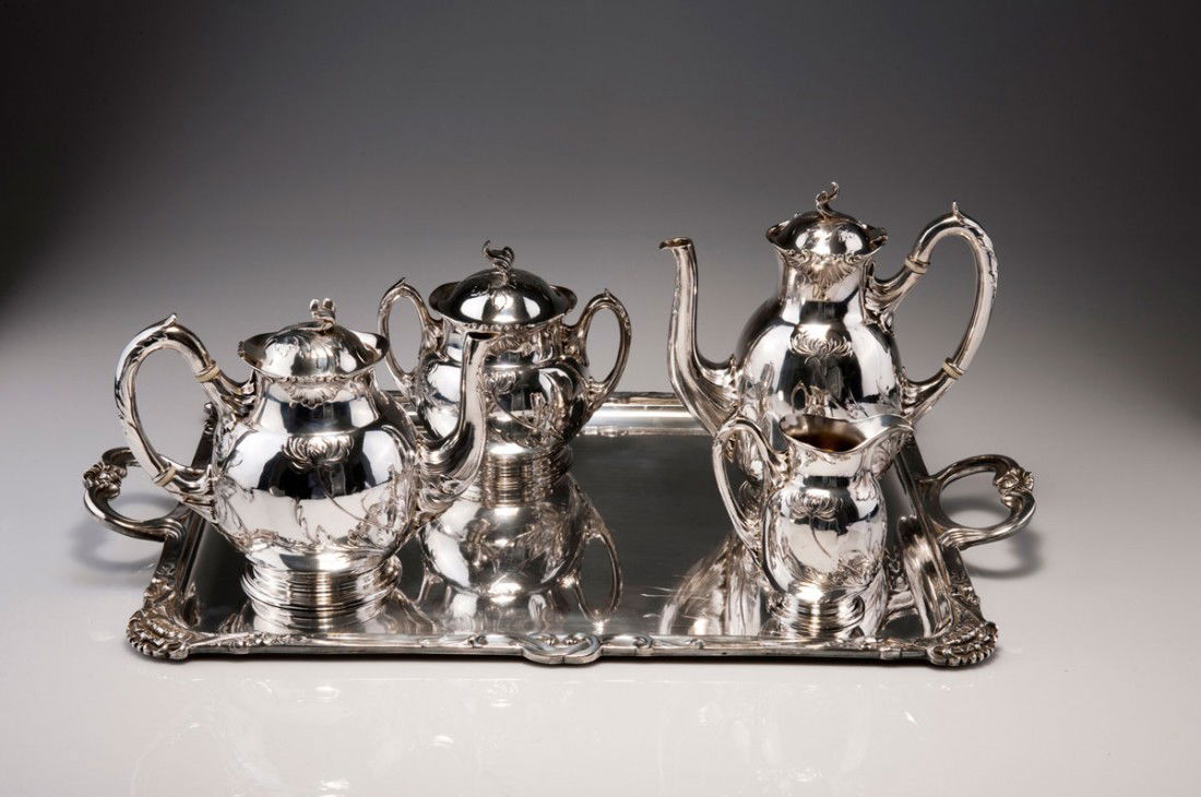 Kaffee- und Teeservice, um 1920: Christofle, Paris. Coffee and teaset, circa 1920. Five pieces. Coffeepot, H. 21.8 cm; teapot, H. 17.9 cm; creamer, H. 12.2 cm; sugar bowl, H. 15.5 cm; tray, 59.5 x 38.2 cm. Silver-plated alpacca, reli