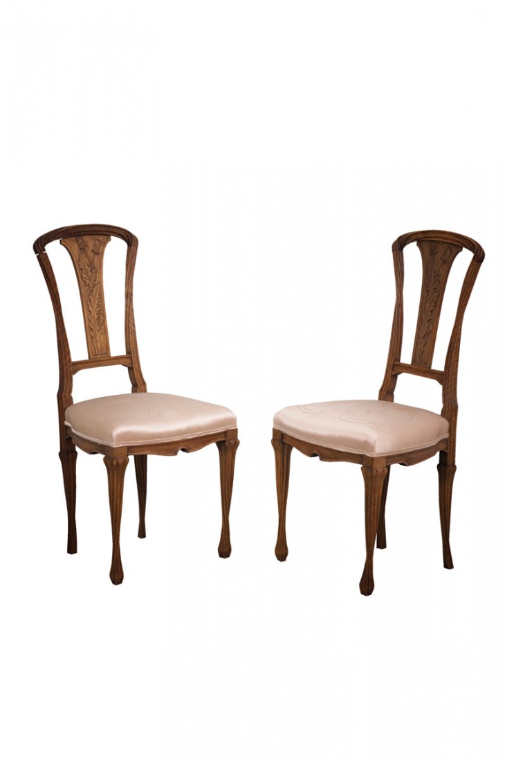 Zwei Stuhle 'Pissenlits', um 1900: Louis Majorelle, Nancy. Two Chairs 'Pissenlits', ca 1900. Raised body on curved legs. H. 86 cm. Seating heigth: 42 cm. Walnut, carved. Backrest with motives of dandy lions. Upholstery mounted with bei