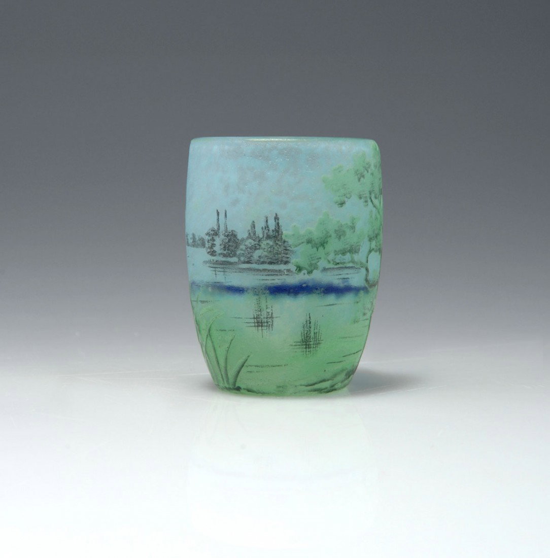 Miniaturvase 'Paysage lacustre', um 1910: Daum Freres, Nancy. Miniature 'Paysage lacustre' vase, circa 1910. H. 5.1 cm. Cased glass, clear, milky light-blue powder inclusions, yellow and green enamel fusions. Etched and enamelled pattern. Lan