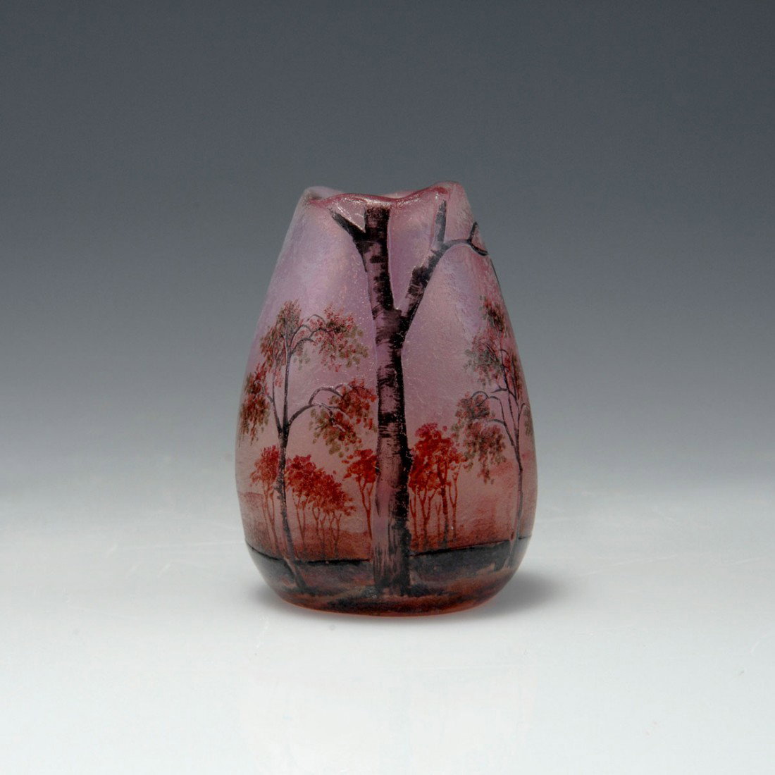 Miniaturvase 'Paysage mauve', 1907: Daum Freres, Nancy. Miniature 'Paysage mauve' vase, 1907. H. 4.5 cm. Cased glass, milky opalescent and clear, pink powder inclusions, roughly etched, enamelled, Grisaille paint. Landscape with birches