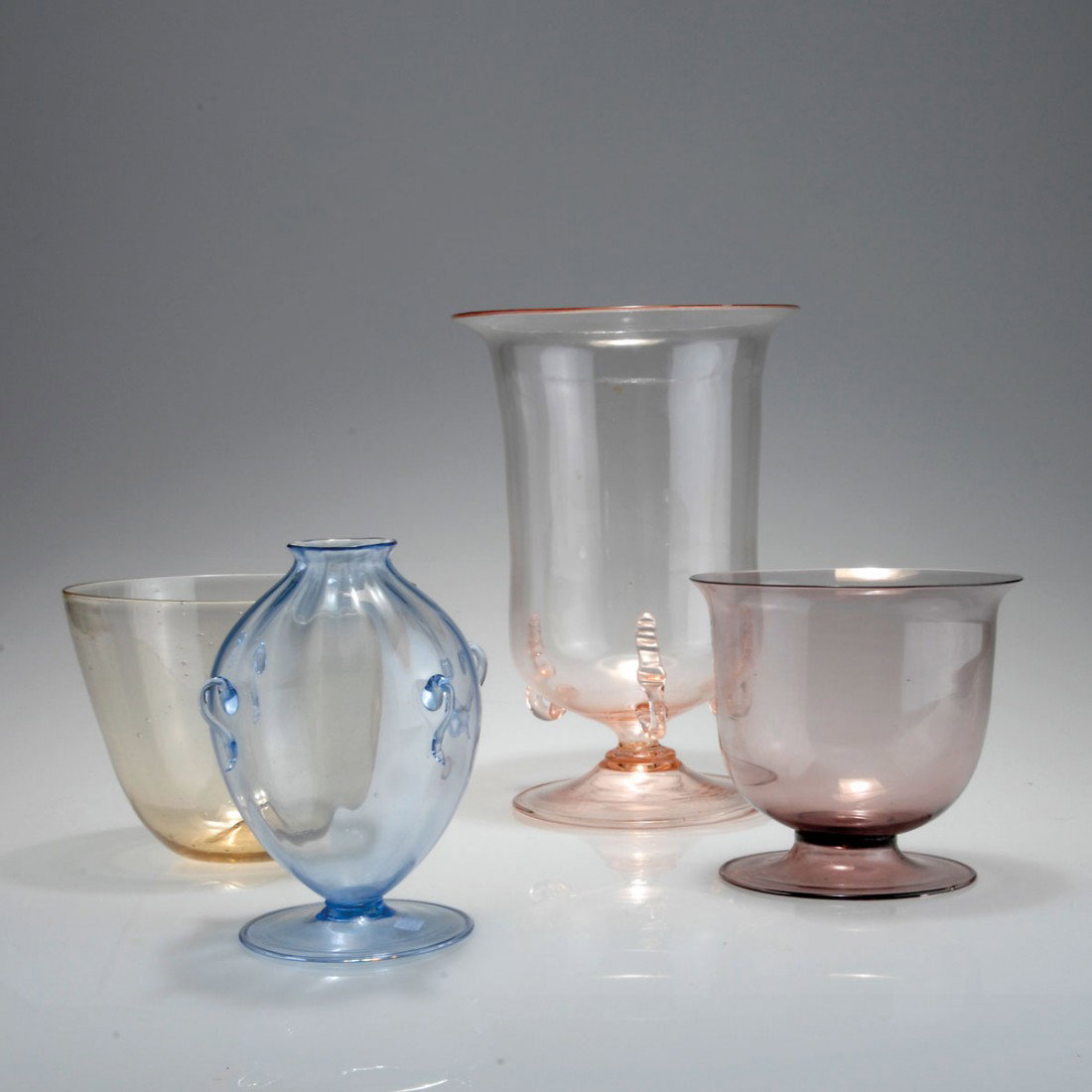 Vier Vasen 'soffiati': Vittorio Zecchin. Four 'Soffiati' vases. H. 13-25.7 cm. Designed c1921-25. Made by M.V.M. Cappellin & C. (attributed). Purple, pink, amber and light blue glass, two vases with applied handles.