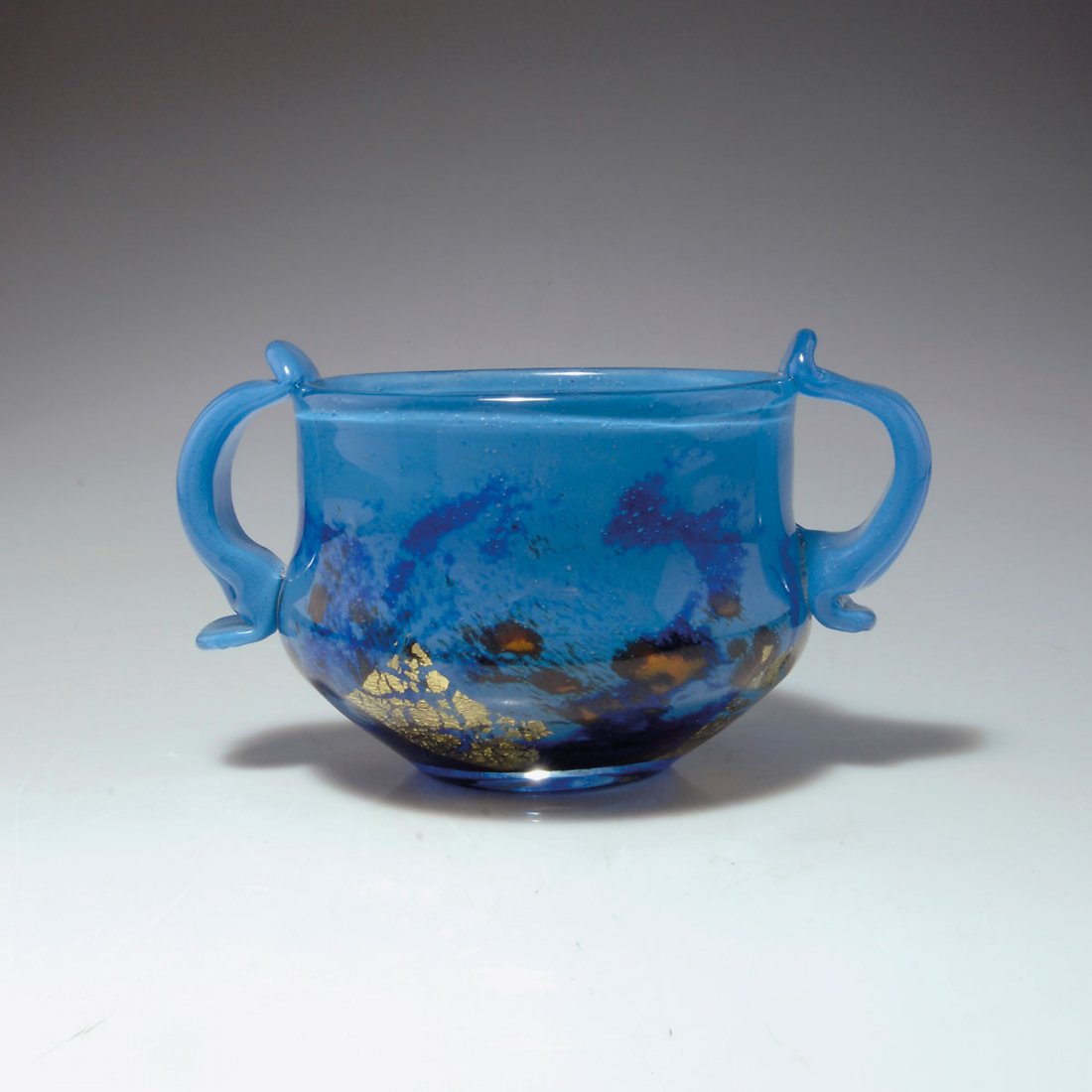 Henkelschale 'Verre de jade', 1918-25: Daum Frères, Nancy. 'Verre de jade' vase with handles, 1918-25. H. 11.8 cm; D. 13.6 cm. Cased glass, clear, bubbly, cloudy powder inclusions in light- and darkblue, orangebrown powders and burst gold