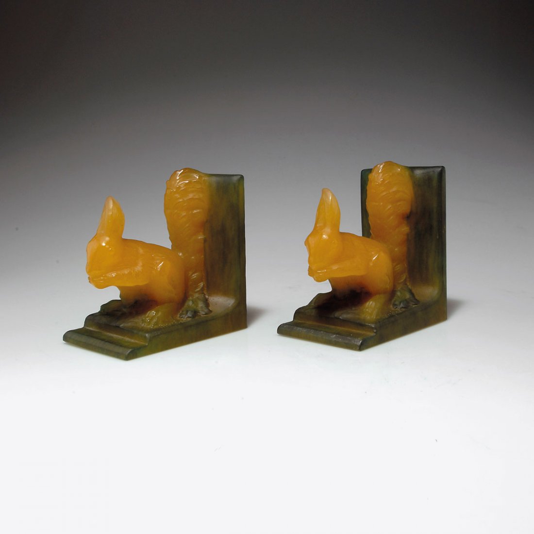 Paar Buchstützen 'Ecureuils', 1920er Jahre: Amalric Walter, Nancy. Pair of 'Ecureuils' bookends, 1920s. H. 13.5 cm; 12 x 8 cm. Designed by Henri Bergé. Pâte de verre, opaque gather, moulded, mostly amber, green powder fusions. Marked: AWALTER