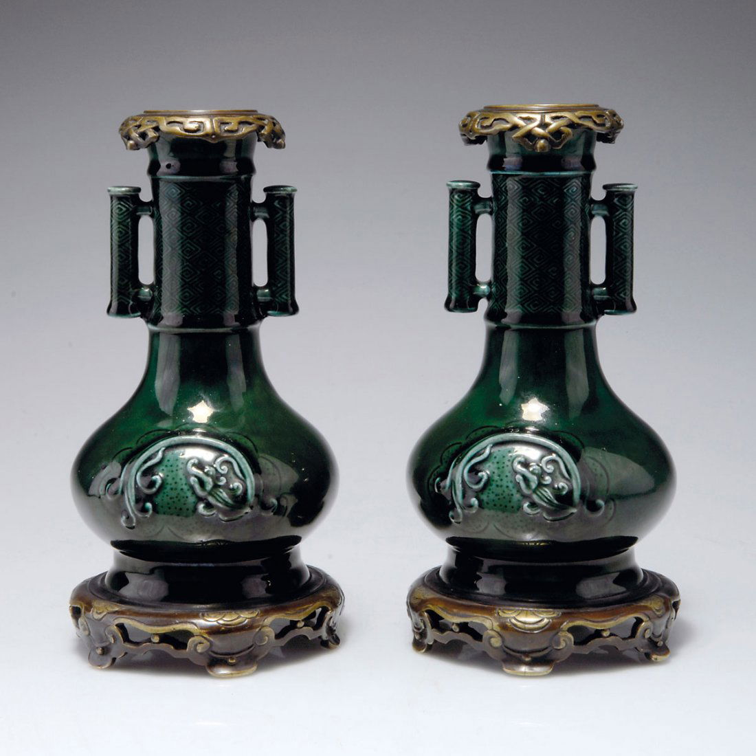 Paar Vasen, um 1870: Théodore Deck, Sèvres. Pair of vases, c1870. Rim and foot with bronze mounting by HP. H. 20.2-20.3 cm. Faience, reliefed pattern, green glaze. Marked: TH DECK.