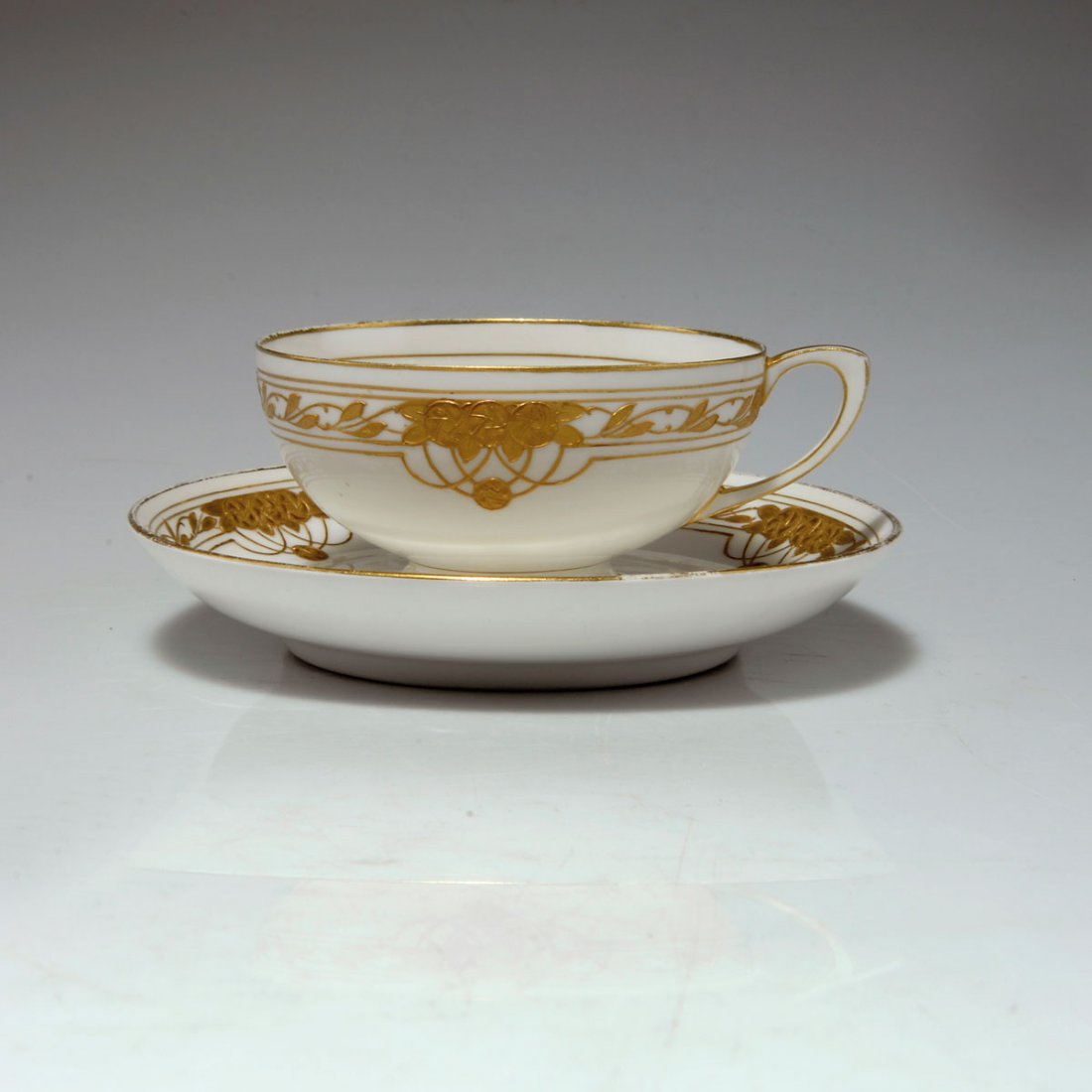 Teetasse mit Unterteller, um 1899: KPM Berlin. Teacup and saucer, c1899. H. 5.2 cm. Pattern by Adolf Flad. Porcelain, white, glazed. Gold relief with twigs and whirls. Marked: Maker's mark, painter shop mark.