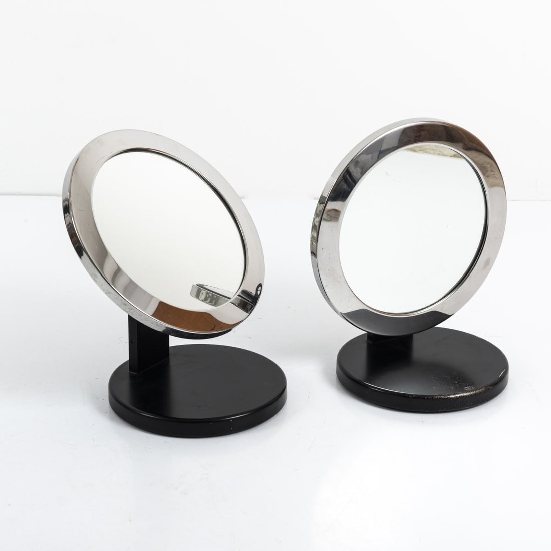 Valentini, Milan, Two table mirrors, 1960s: H. 35.5 cm, Ø 32 cm. Sheet metal, tubular metal, chrome-plated, partially painted black, mirror glass. Marked: manufacturer's label (1x)