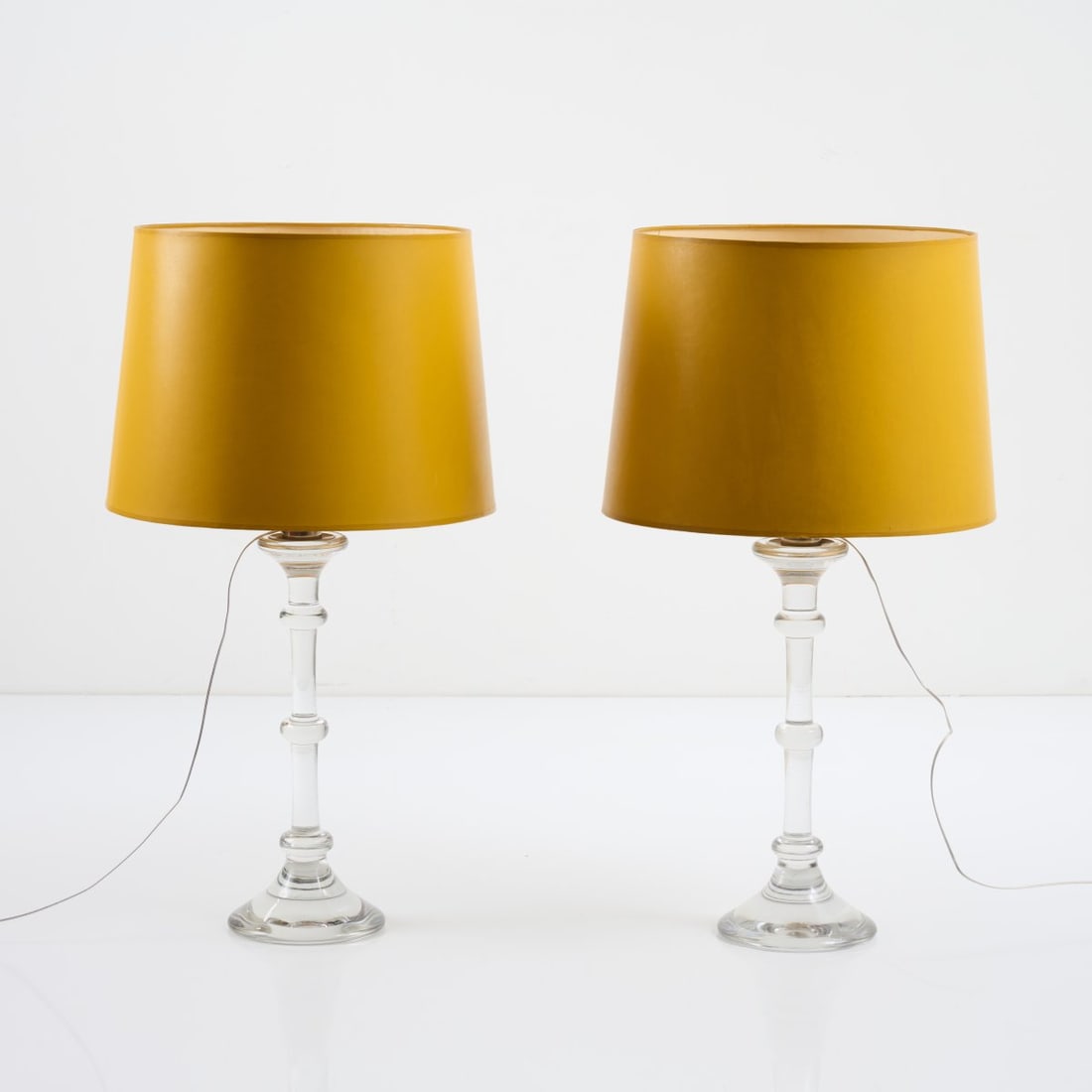 Ingo Maurer, Two 'Tiffany' table lights, 1969: H. 77 cm, Ø 43 cm. Made by Val St. Lambert for Design M, Ingo Maurer Munich. Glass, clear, textile shade, mustard-yellow. Marked: Val St. Lambert (engraved). Literature: Bauer (ed.), Ingo Maur