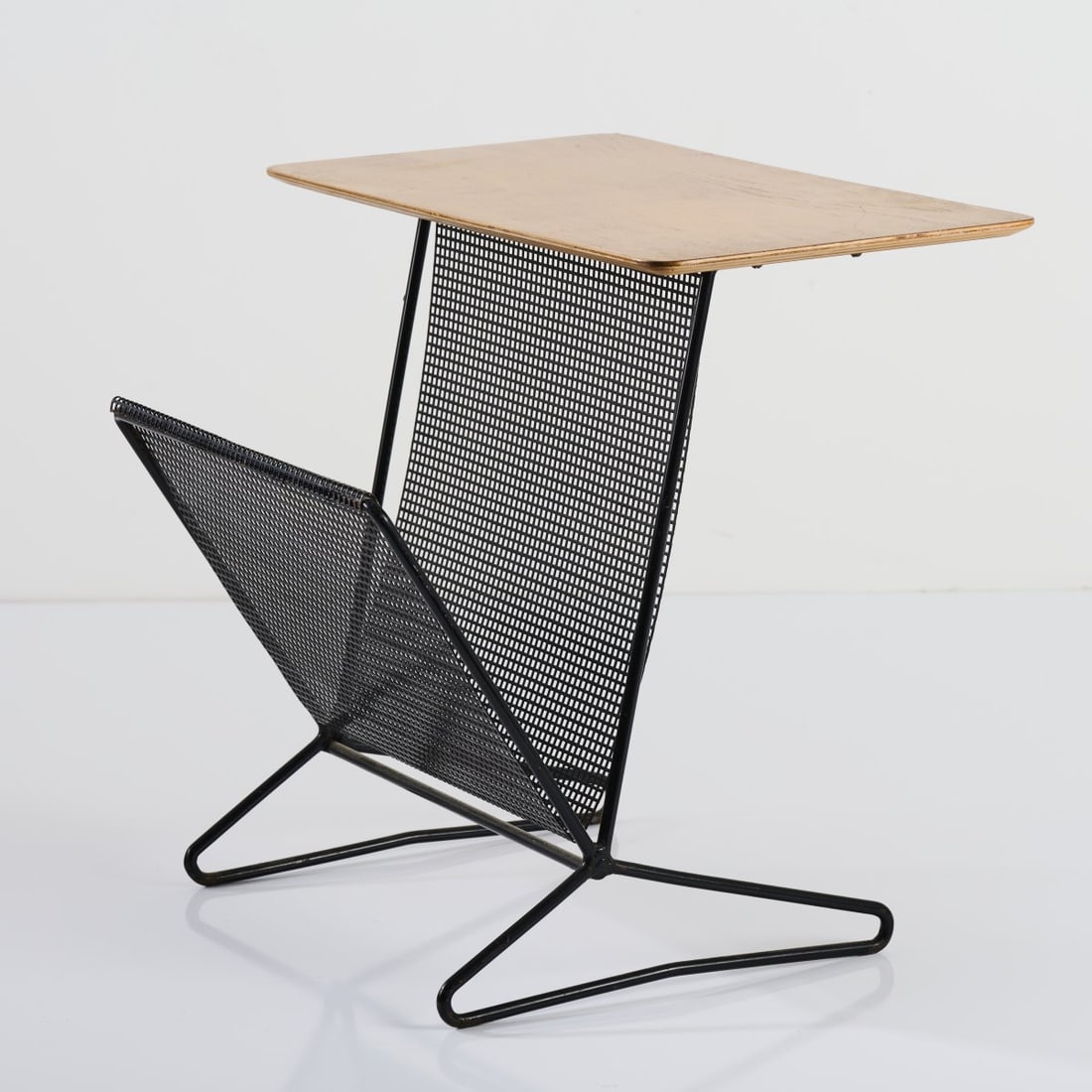Cees Braakman, 'TM-05' side table with newspaper rack, 1954: H. 50 x 55 x 46.5 cm. Made by UMS Pastoe, Utrecht. Tubular metal, perforated sheet metal, painted black, wood.