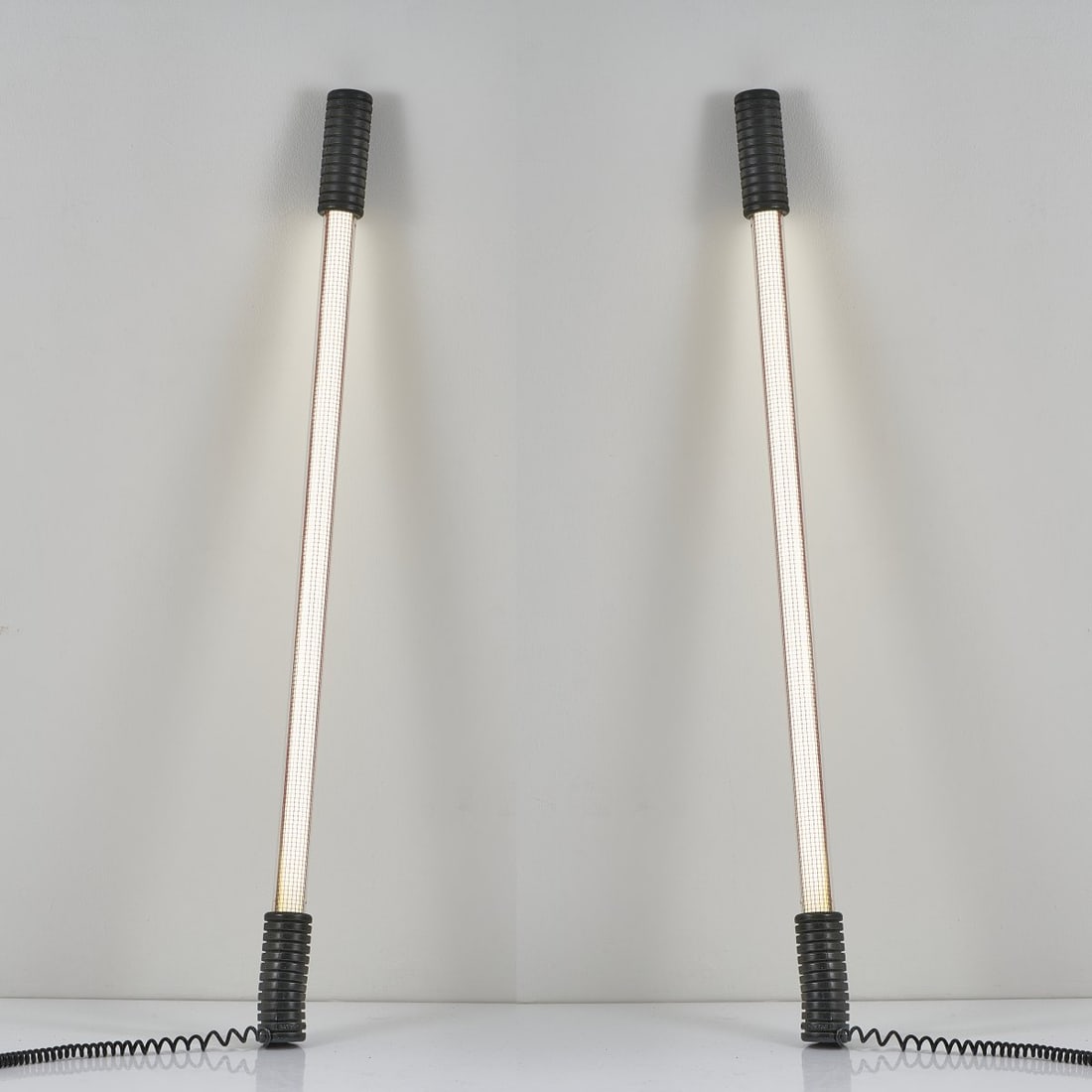 Philippe Starck, Two 'Easylight' floor lamps, 1979: L. 140 cm. Made by Electrorama, Paris. Plexiglas, clear, metal grid, painted red, fluorescent tube, rubber, black. Marked: Starck Product (embossed).