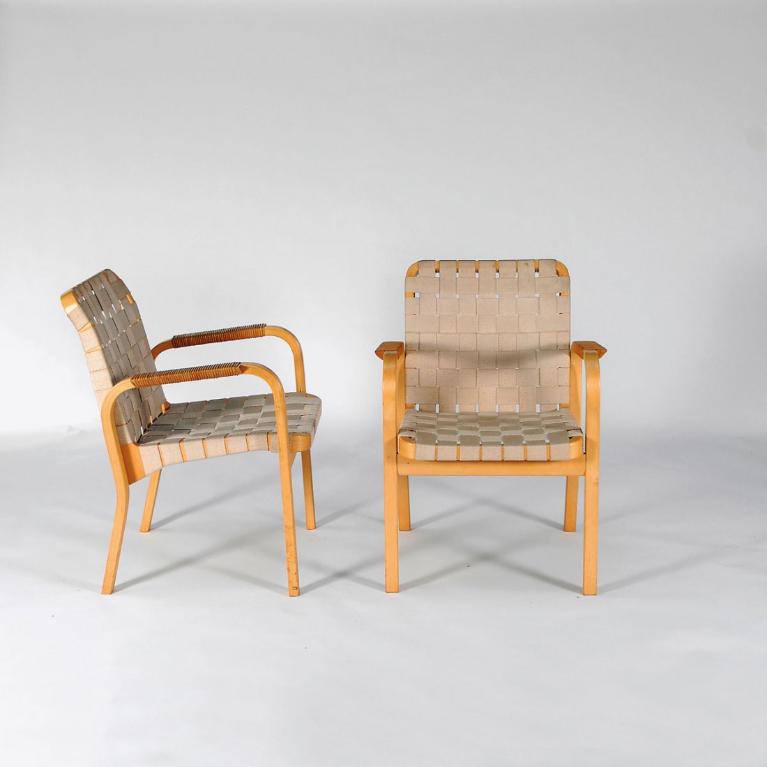 Alvar Aalto. Pair of '46' armchairs: Alvar Aalto. Pair of '46' armchairs, designed c1947. H. 80 x 61 x 64.5 cm. Made by Artek, Helsinki, probably in the 1980s. Birchwood, birch plywood, linen straps, wickerwork.