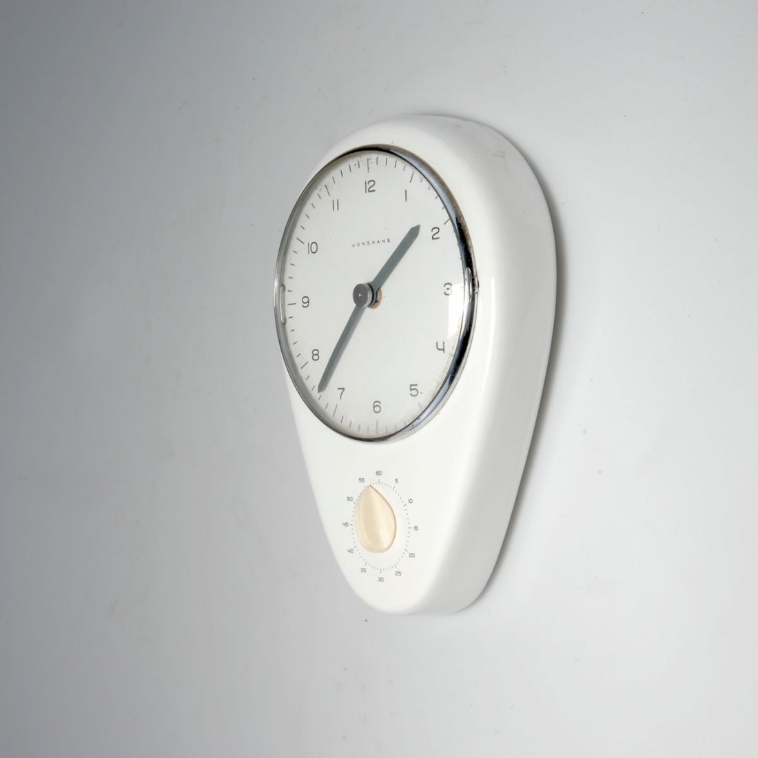 Max Bill. Kitchen clock: Max Bill. Kitchen clock, designed in 1956-57. 26 x 18.5 cm. Made by Junghans, AG, Schramberg, in the 1950s. Earthenware, glazed white, metal, painted creme-white, clear glass, white plastic. Marked: J