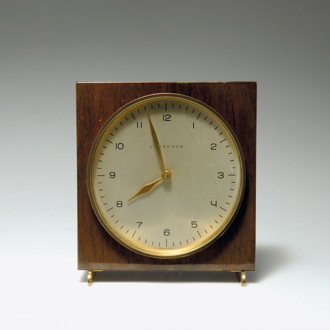 Max Bill. Table clock: Max Bill. Table clock, designed in 1959. H. 17.5 x 16.3 x 7 cm. Made by Junghans, Schramberg. Plywood, nutwood veneer, brass. Marked: JUNGHANS MADE IN GERMANY.