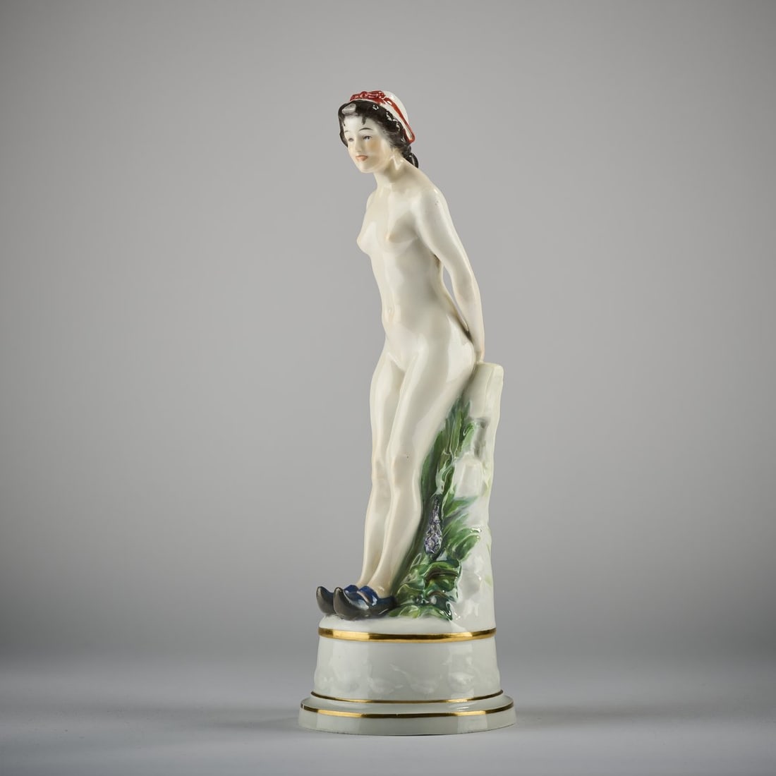 Joseph Cormier alias Joé Descomps, 'Girl Nude', 1909-11: H. 31 cm. Executed by KPM Meissen, before 1924. Porcelain, white, glazed, polychrome overglaze with gold. Marked: button swords (blue, underglaze), A 296 (incised), 51 (embossed), 36 (brown, handwritt