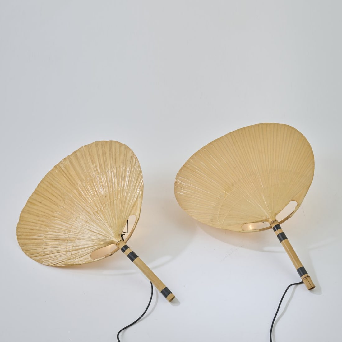 Ingo Maurer, Two wall lights 'Uchiwa III', 1973: H. 74 cm. Made by Design M, Ingo Maurer, Munich. Bamboo cane, rice paper.