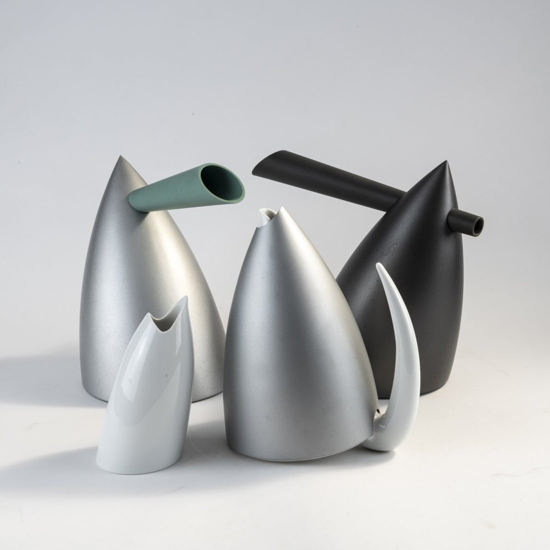Philippe Starck, Two 'Hot Bertaa' coffeepots, 'Ti Tang' tea pot and 'Sumi Tang' creamer, 1990/91: H. 14.5 - 26 cm. Made by Alessi, Crusinallo, and Alessi Tendentse, Milan. Porcelain, white, glazed, plastic, green and anthracite, aluminum sheet. Marked: manufacturer's marks. Literature: Philippi (