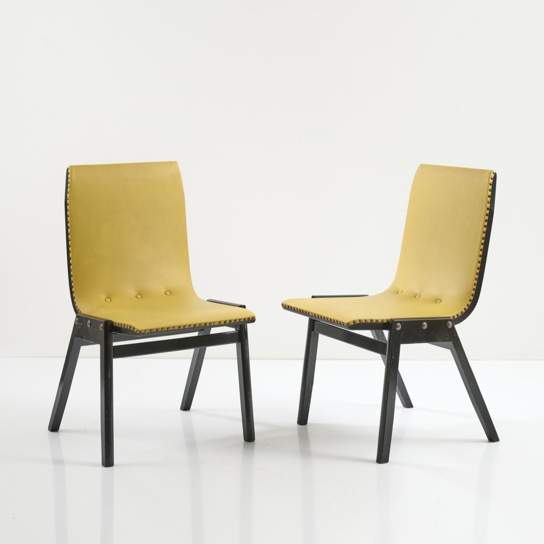 Roland Rainer, Two chairs 'Stadthallenstuhl' - 'Variant', c. 1954: H. 78 x 45 x 57 cm. Made by Pollak, Vienna. Wood, painted black, yellow vinyl.