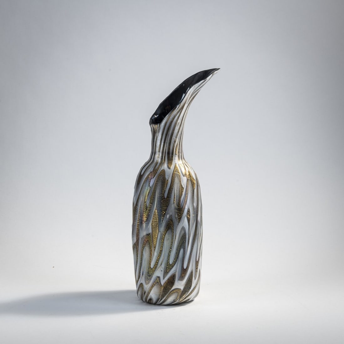 Gino Cenedese, 'Variegato' jug, 1950: H. 31.2 cm. Deep violet glass with streaky fusions in opaque white and gray, shattered gold foil, iridescent. Literature: Marina Barovier, Rosa Barovier Mentasti, Attilia Dorigato, Il Vetro di Murano