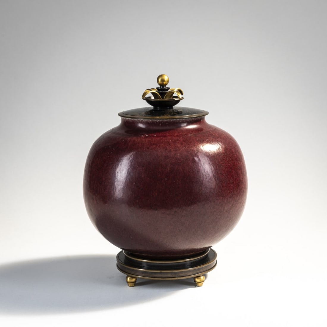 Carl Halier, Karl Andersen, Vase with bronze lid and stand ring, 1923-29: H. 23 cm (total). Execution: KPM Copenhagen, 1959. Stoneware, dark red high-firing glaze. Marked: ROYAL COPENHAGEN DENMARK (green glaze stamp), waves, artist's signet (unidentified) (blue). Bronze par