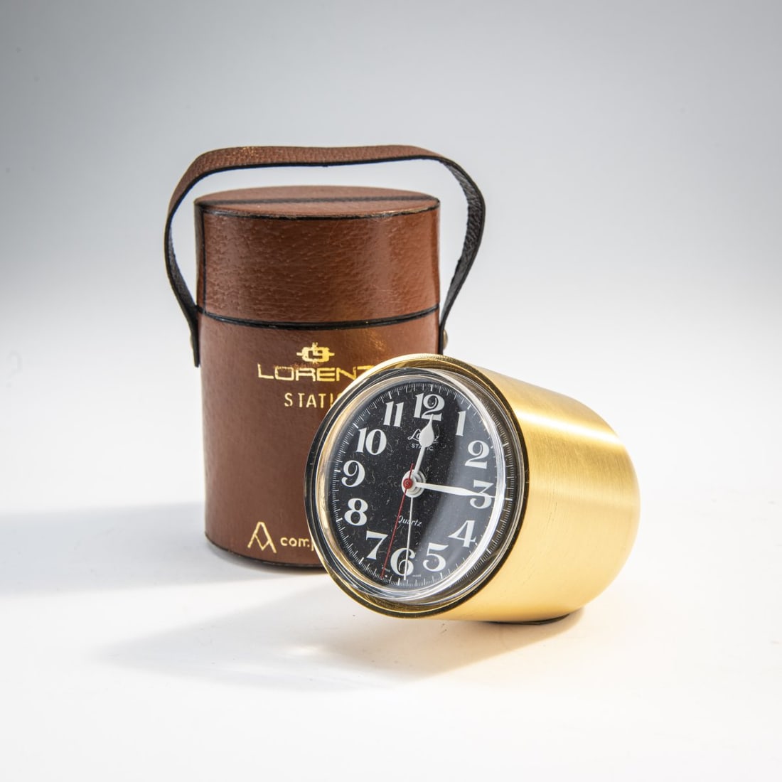 Richard Sapper, 'Static' table clock, 1959: H. 8 x 6.5 x 10 cm. Made by Lorenz, Milan. Brass, clear plastic, sheet metal, brown leather, felt. Marked: manufacturer's embossing.