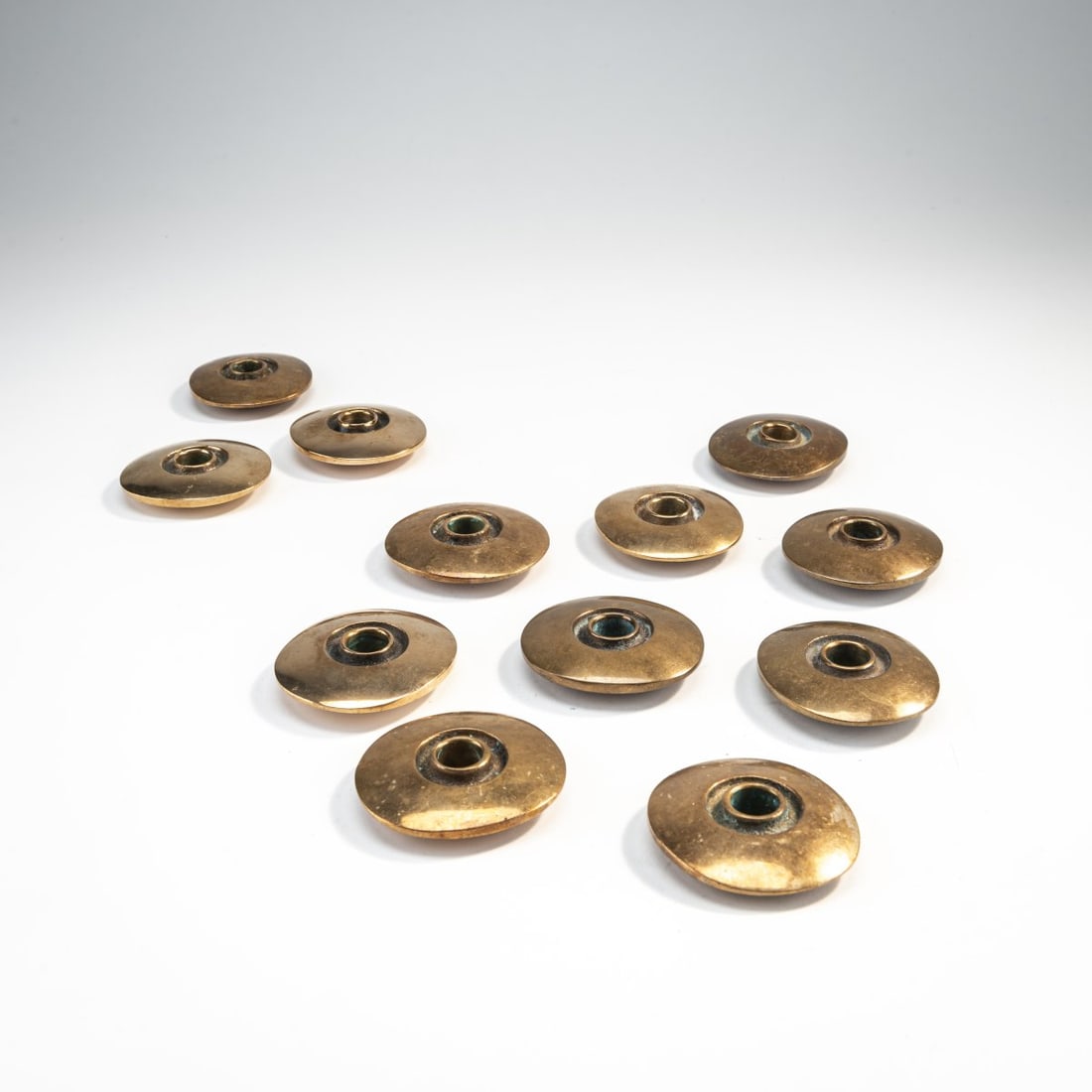 Bertel Gardberg, Twelve Candle Holders, 1957: Ø 6 cm. Made by Boda, Finland. Bronze. Marked: manufacturer's mark.