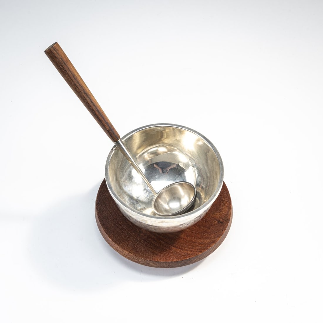 Bertel Gardberg, Soup bowl with spoon, c. 1960: Bowl: H. 8.5 cm; spoon: L. 21 cm. Made by Hopeatehdas Oy, Helsinki, 1960 or 1964. Teak, silver. Marked: manufacturer's mark, crown, silver mark, city mark, date mark L7 or G7, artist's signet.