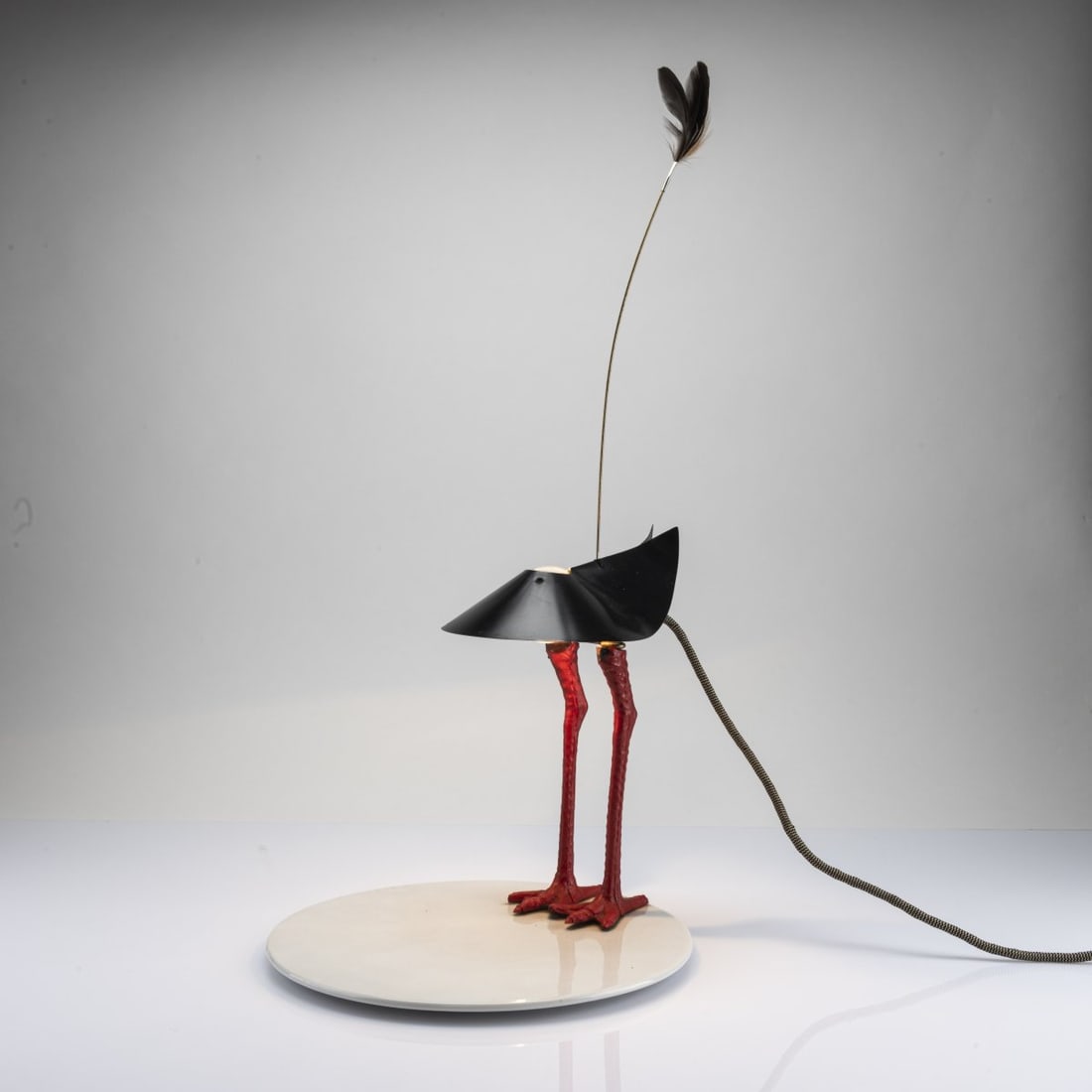 Ingo Maurer, 'Bibibibi' table light, 1982: H. 62 cm, Ø 29.5 cm. Made by Design M, Ingo Maurer, Munich. Porcelain, plastic, red, sheet metal, painted black, feathers. Marked: facsimile signature, numbered 111/500. Literature: Exh. cat.