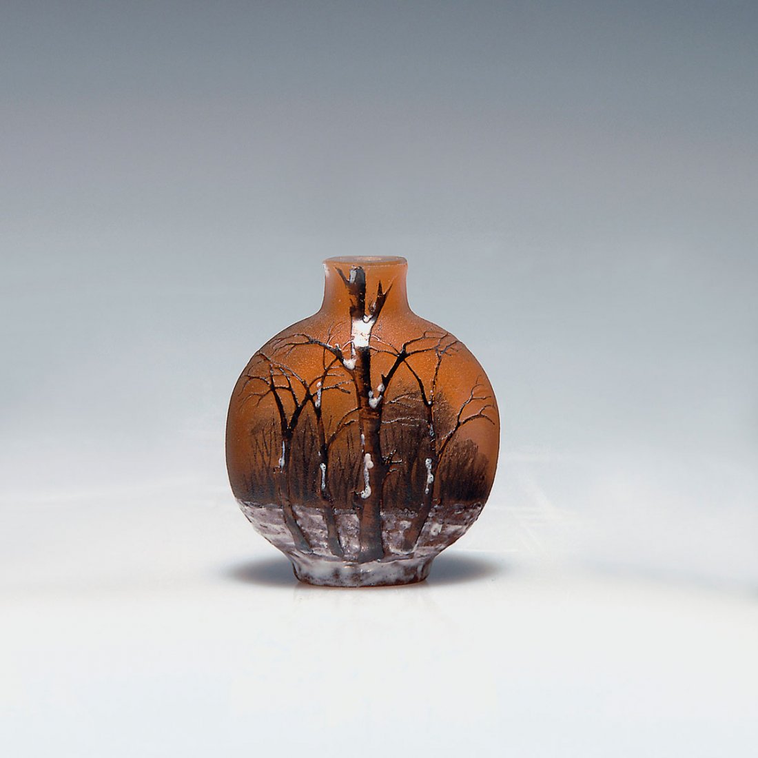 Miniature 'Arbres en hiver' vase, c1910: Daum Freres, Nancy. Miniature 'Arbres en hiver' vase, c1910. H. 4.3 cm. Cased glass, clear, white and orange powder inclusions. Rough ground. Grisaille paint, white enamel. Trees in Winter at dusk. Si