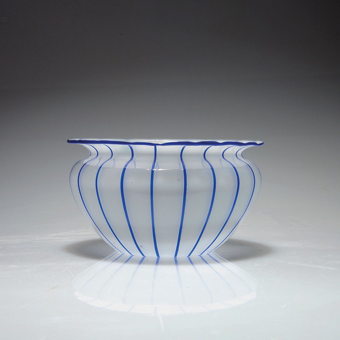 Vase, 1914-20: Loetz, Klostermuhle. Vase, 1914-20. H. 12.1 cm. Designed in the style of Michael Powolny. Cased glass, clear and opal white, applied blue stripes and threads.