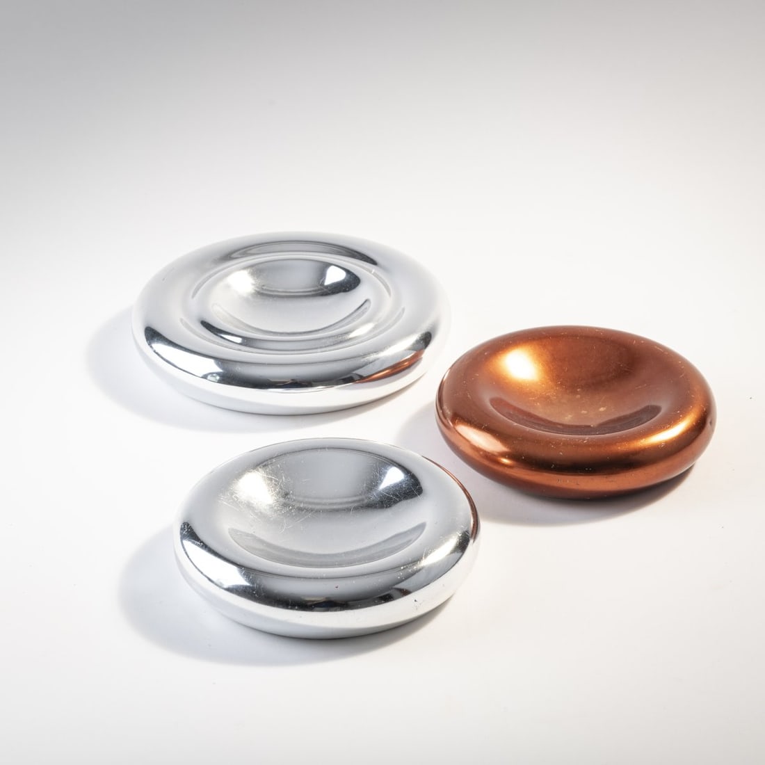 Ingo Maurer, Three bowls, c. 1970 (design): Ø 18 - 22 cm. Design M, Ingo Maurer, Munich. Aluminum sheet, one anodized copper red.