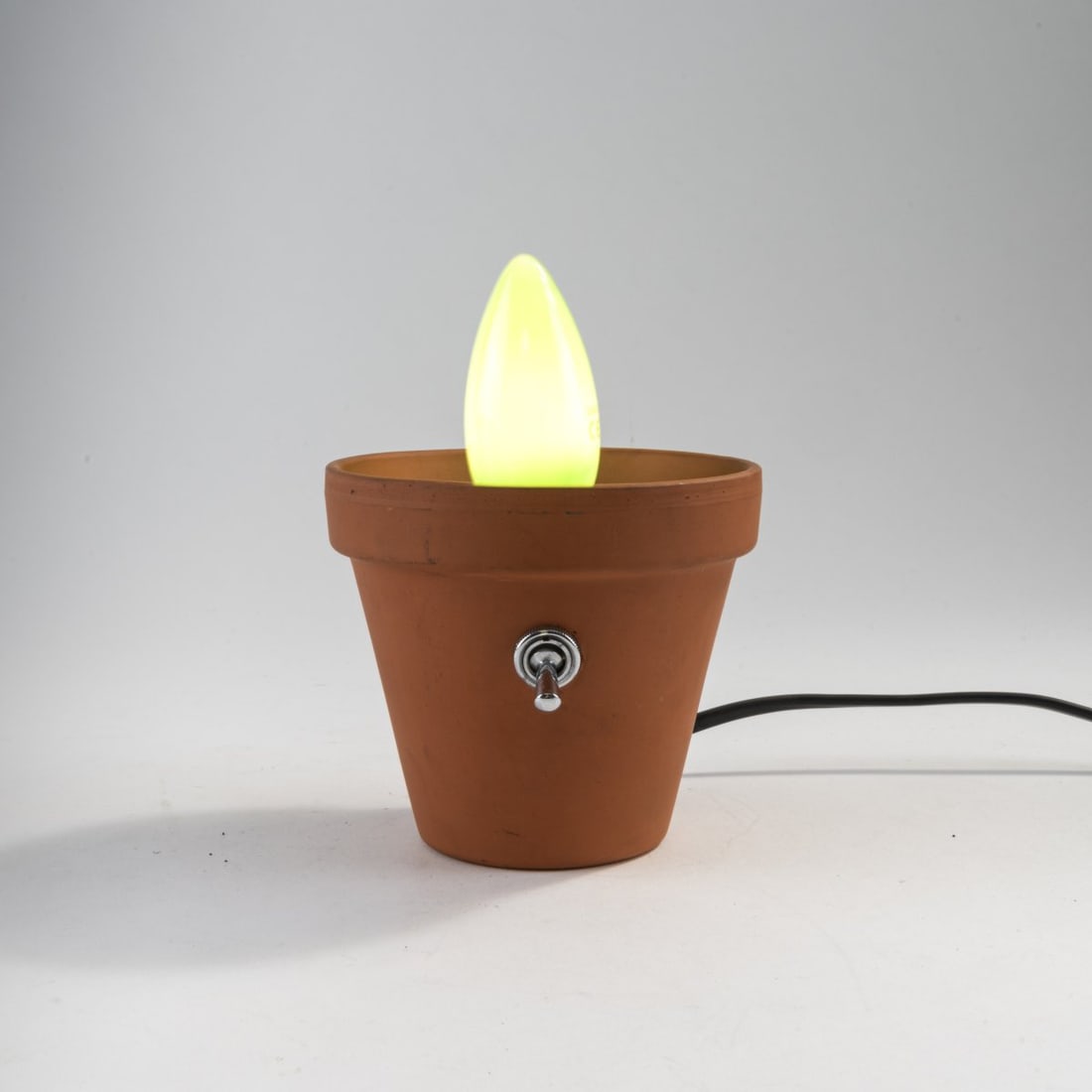 Stiletto; Frank Schreiner, 'Pflanzlicht' light object, 1984 (design): H. 16 cm. Stiletto Studios, Berlin, 1989. Clay pot, soil, green light bulb. Marked: "Pflanzlicht" No. 43, 09/11/89, Stiletto Studios (incised). Literature: Kunstforum, vol. 82, n.p. 1985, p