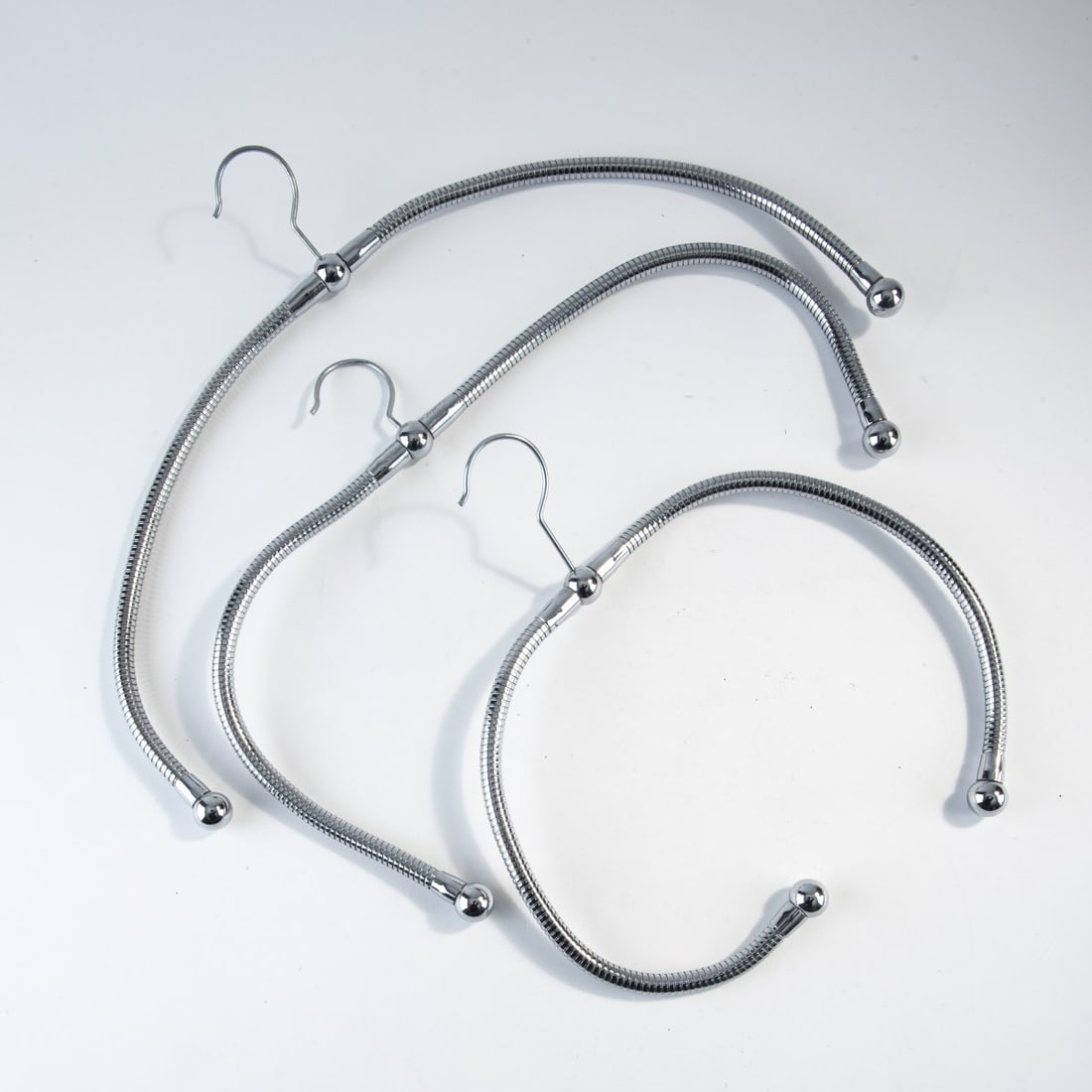 Stiletto; Frank Schreiner, Nine 'Schlawittchen' coat hangers, 1989 (design): Approx. 20 x 35-40 cm.Stiletto Studios, Berlin, 1989/90. Goosenecks, metal. Marked: "Schlawittchen", numbered: 8/23/50/51/63/67/69/70/72, dated, Stiletto (engraved on each coat hanger).