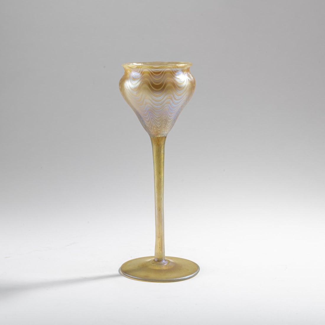 Franz Hofstötter, 'Phänomen' goblet, 1899: H. 23.5 cm. Execution: Loetz, Klastersky Mlyn. Cased glass, colorless, ribbed decoration of silver-yellow threads, candia Phänomen Gre 6893, strong pearlescent matt luster. Literature: Mergl/Plo