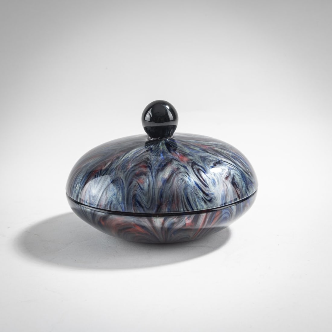 Loetz, Klastersky Mlyn, 'Titania' lidded box, c. 1906: H. 8 cm, Ø 12 cm. Cased glass, opaque red and colorless, Titania decoration made of silver-yellow threads.