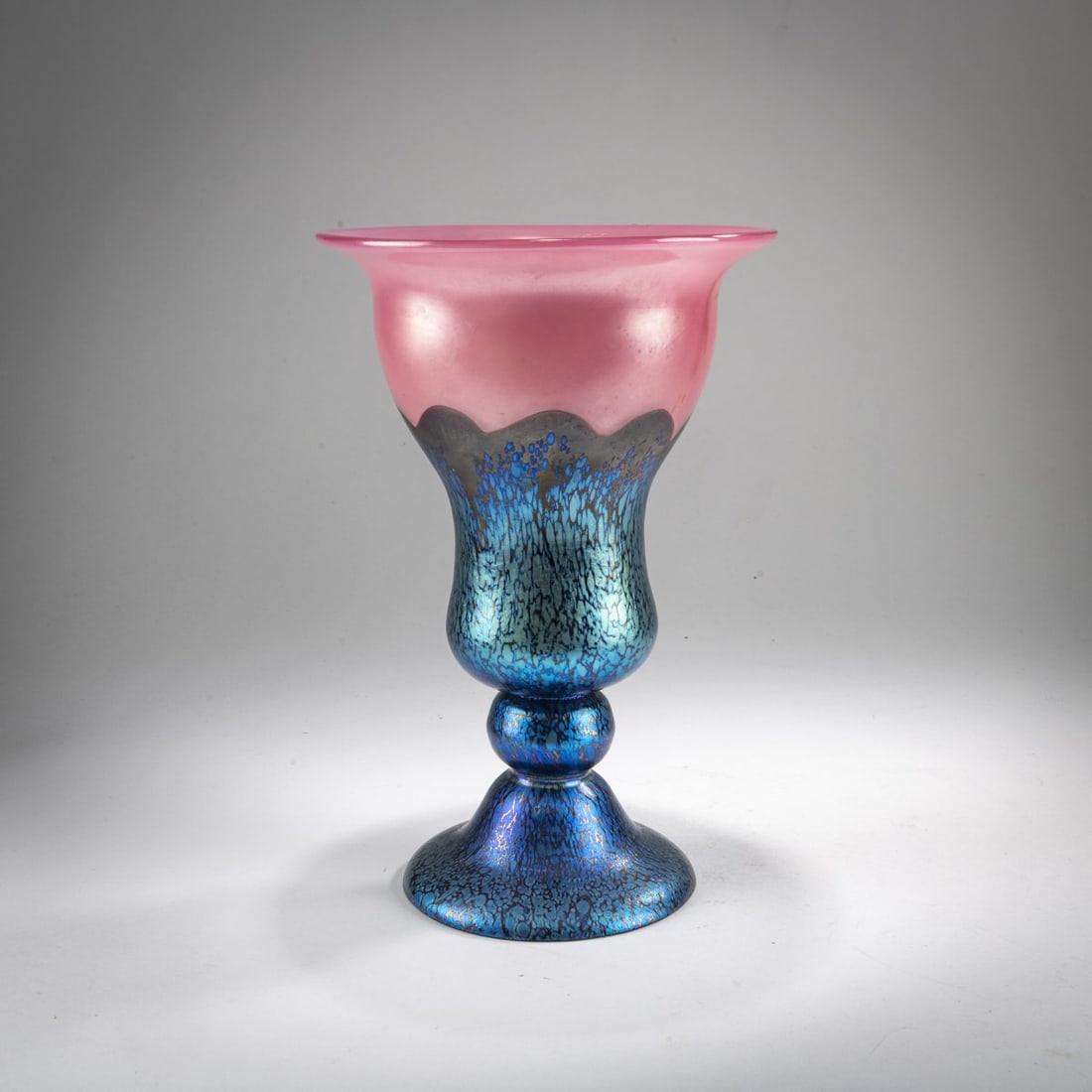 Loetz, Klastersky Mlyn, Tall footed vase, c. 1925: <p>H. 25.5 cm. Cased glass, colorless, opalescent pink, and violet. Blue crushed glass with a matte petrol and pearlescent luster. Execution 226, camellia red.</p>
